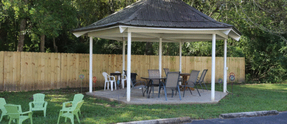 a gazebo with a table and chairs in a yard