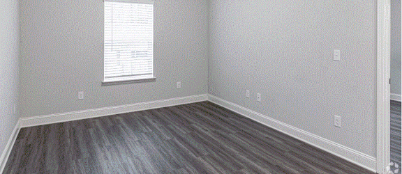 an empty bedroom with gray walls and white trim