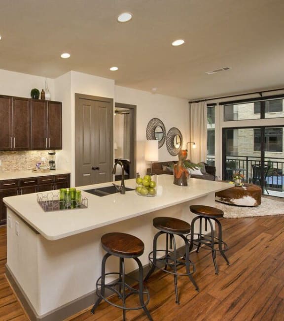 a kitchen with a large island and stainless steel appliances
