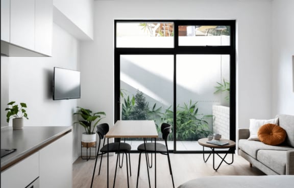 a living room with a green couch and a balcony