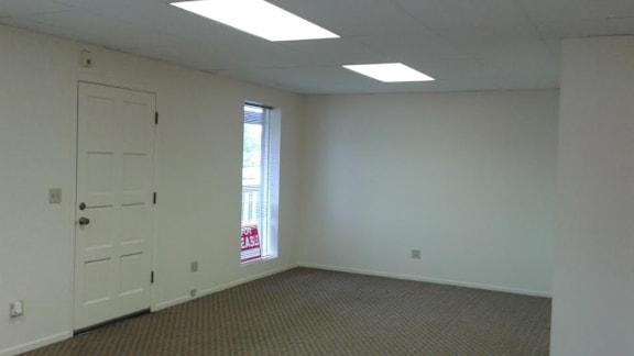 an empty room with a door and a window