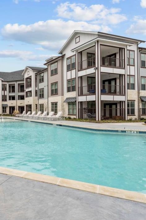an empty pool with an apartment building in the background