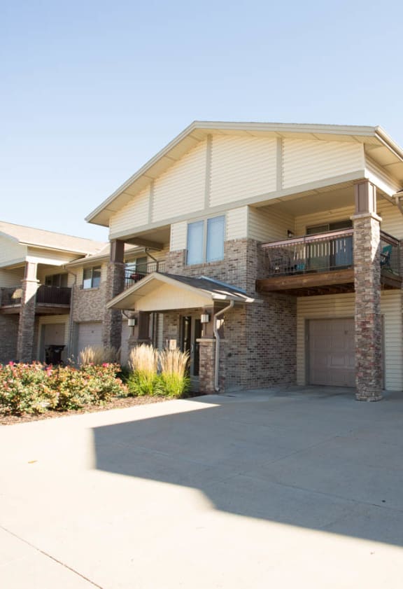 an empty driveway in front of a building with garages