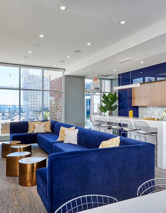 A blue couch with a white pillow is in the middle of a room.