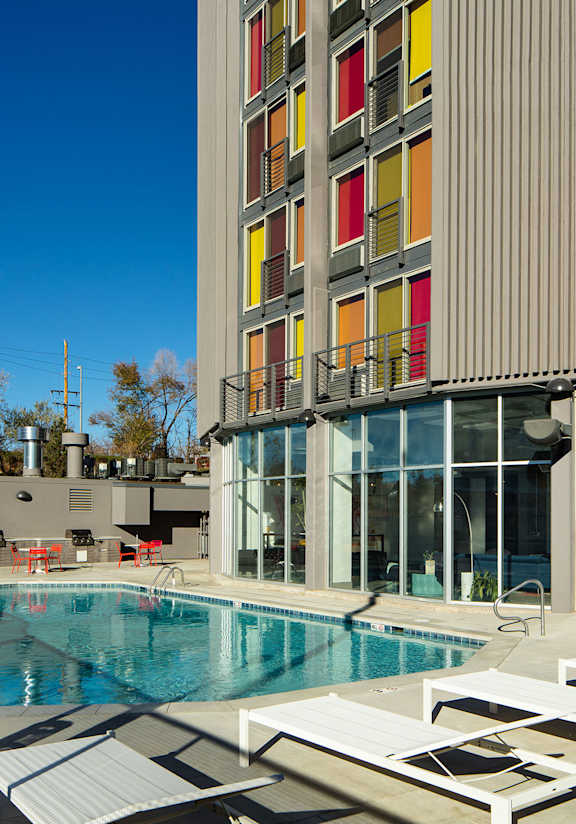 A tall building with a pool in front.