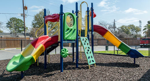 a playground with several slides and a clock
