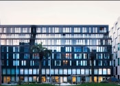 Thumbnail 3 of 7 - a glass building with palm trees in front of it