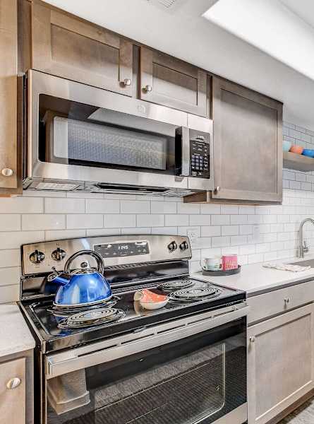 A kitchen with a stove, microwave, and refrigerator.