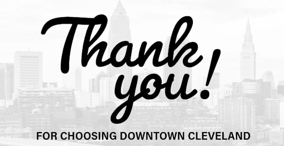 A thank you message for choosing downtown Cleveland with a city skyline in the background.