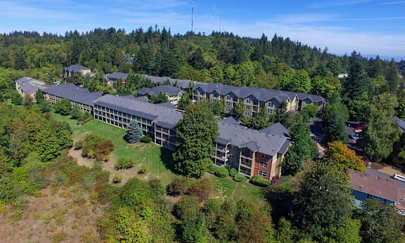 A large building complex surrounded by trees at Commons at Sylvan Highlands Apartments, Oregon, 97225