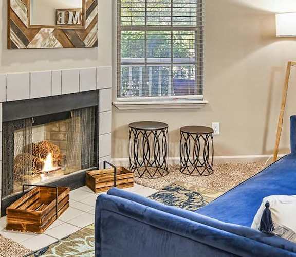 A cozy living room with a fireplace and a blue couch.