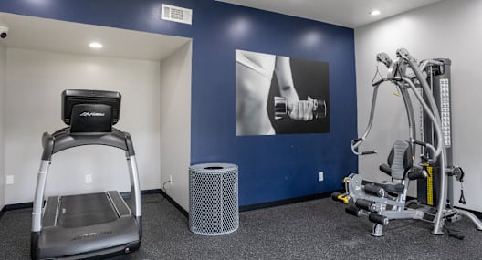a gym with exercise equipment and a poster on the wall