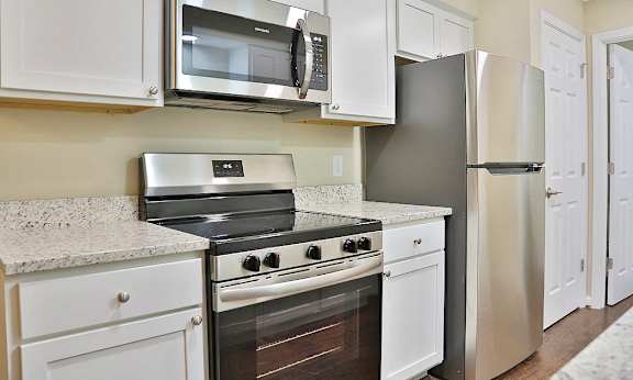 A kitchen with white cabinets and stainless steel appliances.