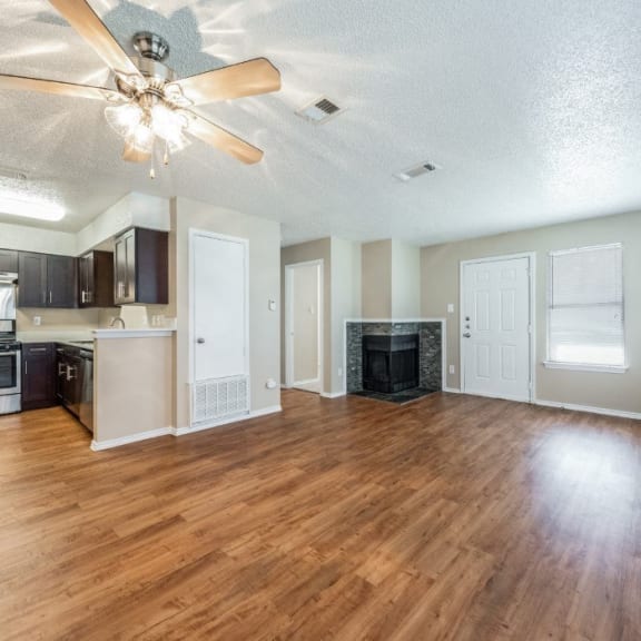 an empty living room with wood floors and a fireplace