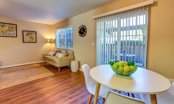A dining room with a table and chairs and a bowl of fruit on the table. at Commons at Hawthorn Village Apartments, Hillsboro, OR, 97124