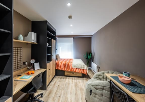 a bedroom with a bed and a desk in a small room
