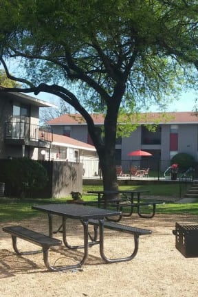 a patio with chairs and a blue umbrella