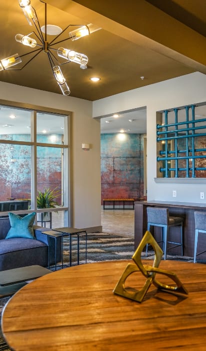 A modern living room with a round wooden table and a large window.