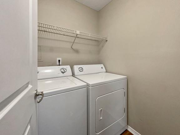 an empty laundry room with two washes and a dryer