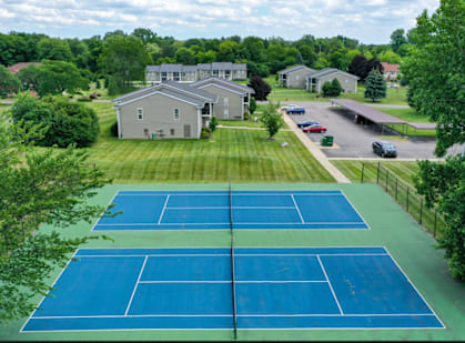 an aerial view of a tennis court with houses in the background