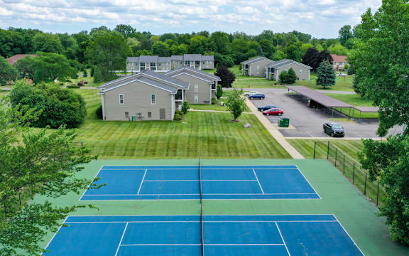 an aerial view of a tennis court with houses in the background