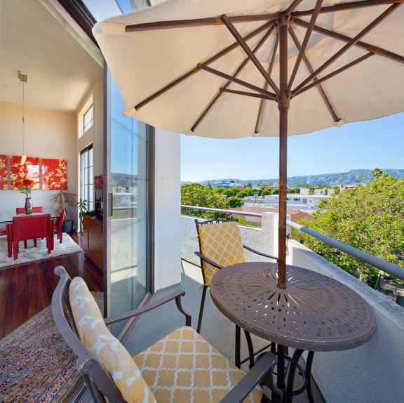 A patio with a table and chairs under an umbrella.