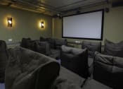Thumbnail 5 of 8 - a theater room with a projector screen and chairs