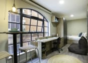 Thumbnail 2 of 8 - a room with a large window and a desk with a chair