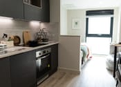 Thumbnail 4 of 8 - a small kitchen with a stove and a table