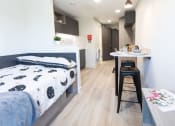 Thumbnail 6 of 8 - a bed and a kitchen in a small room