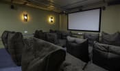 Thumbnail 3 of 8 - a theater room with a projector screen and chairs