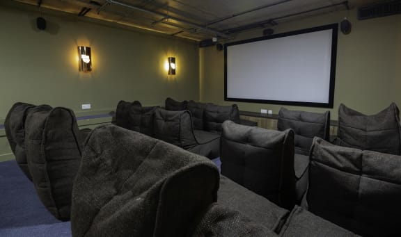 a theater room with a projector screen and chairs