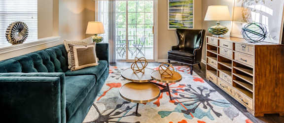a living room with a green couch and a rug