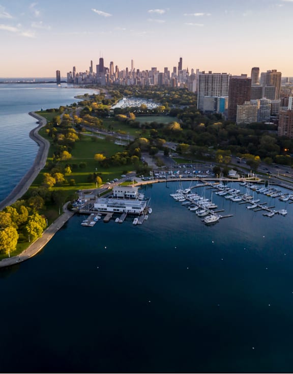 A city skyline is visible from a distance across a body of water.