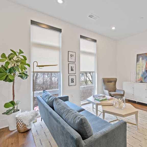 Living room with white walls and a blue couch at Four23/Hoge, Cincinnati, OH
