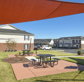 Outdoor Grilling Area with Sun Canopy and Picnic Tables