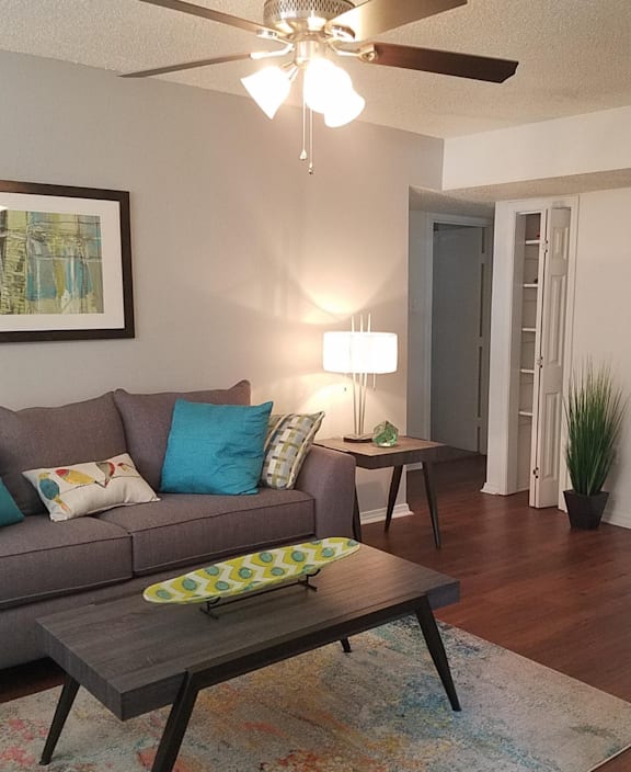 a living room with a small grey couch and coffee table
