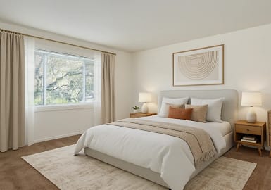 A bedroom with a large bed, a nightstand, and a window with curtains.