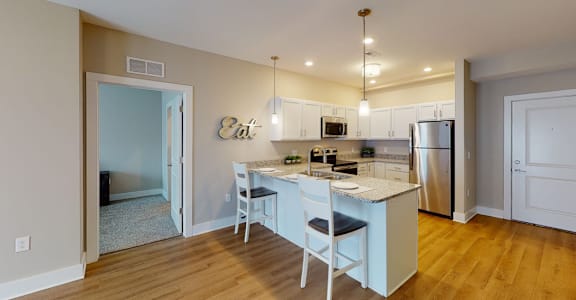 A kitchen with a table and chairs in front of it.