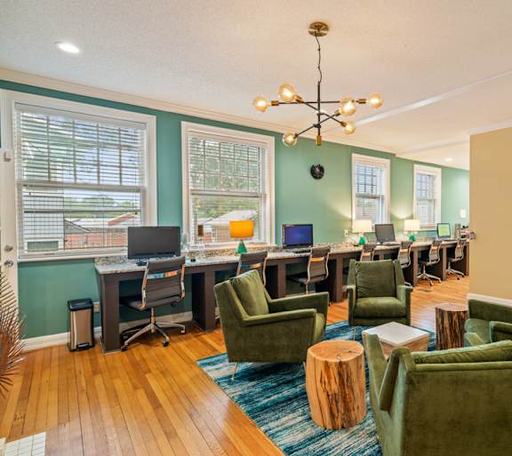 A room with green chairs and a wooden floor.