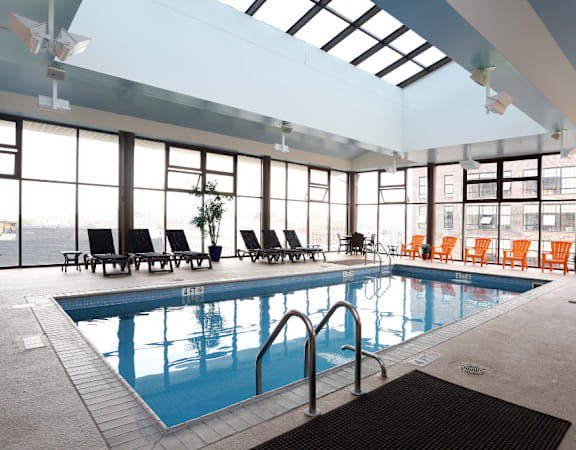 a swimming pool in a large room with floor to ceiling windows