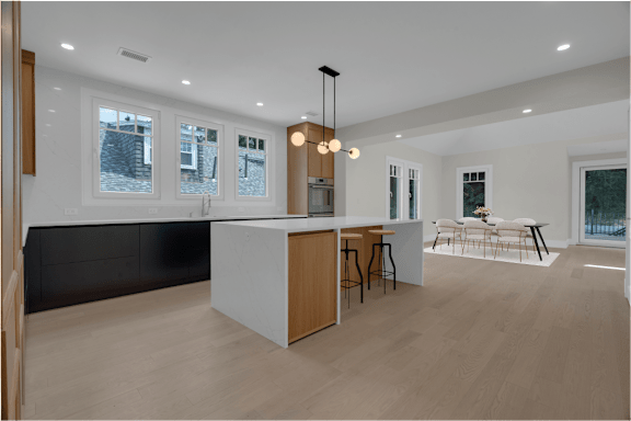 a large white kitchen with a large island and a table with chairs