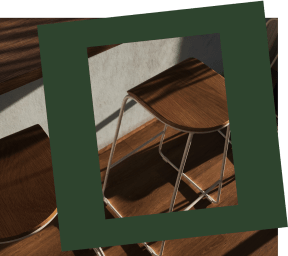 two wooden stools and a bar table on a staircase