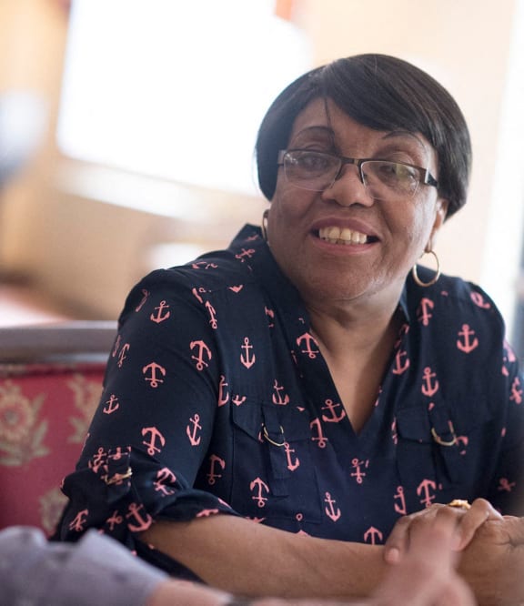 a woman sitting in a chair smiling at the camera