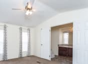 Thumbnail 9 of 18 - a living room with white walls and a ceiling fan