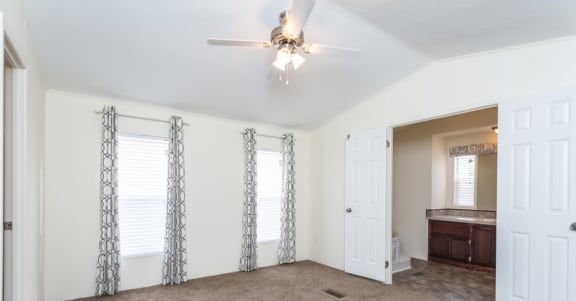 a living room with white walls and a ceiling fan