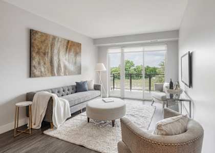 a living room with a couch and a chair and a sliding glass door