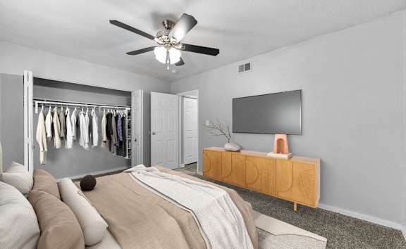 A bedroom with a bed, a TV, and a wardrobe.