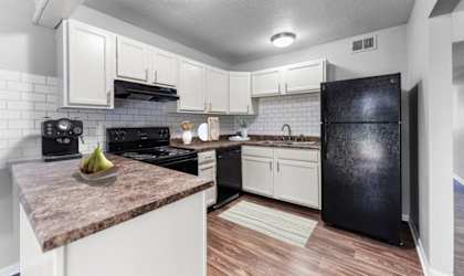 A kitchen with black appliances and white cabinets.