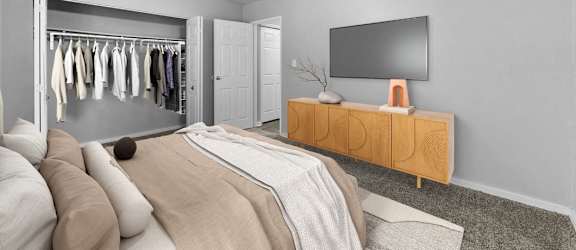 A bedroom with a bed, a TV, and a wardrobe.
